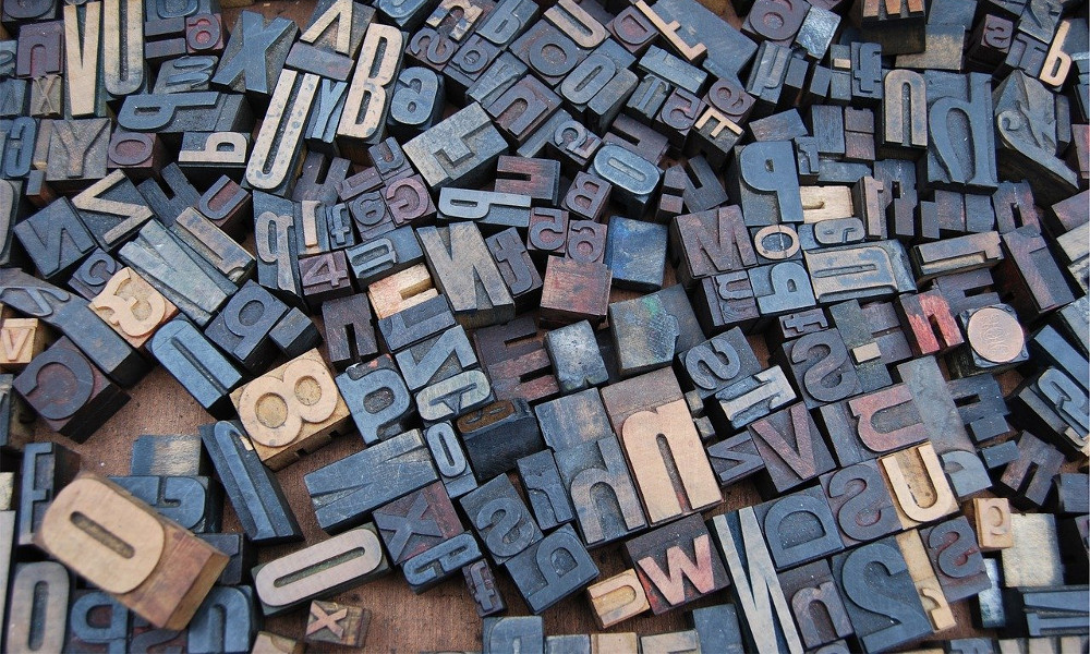 Block letters, used for typesetting, strewn across a desk.